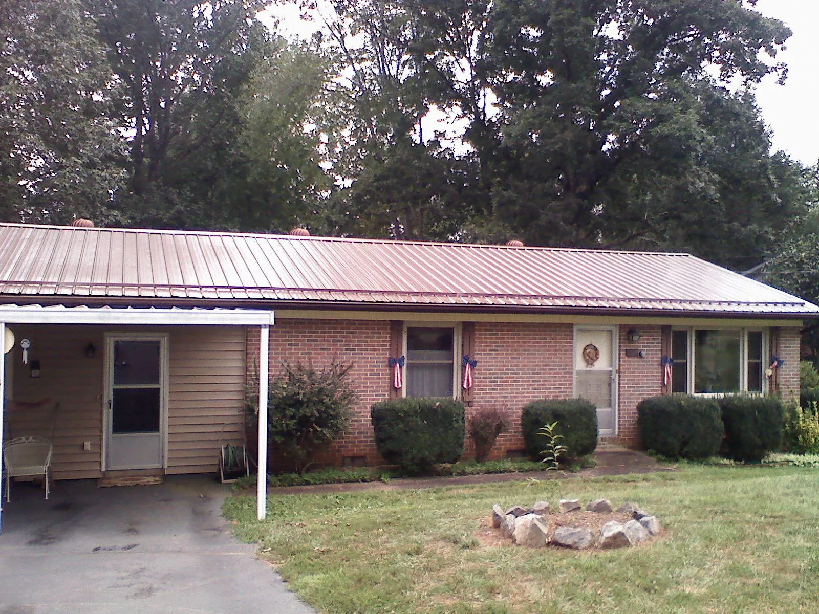 Bronze metal roof and carport on a brick ranch home — Roof Repair work by our crew in Locust Grove