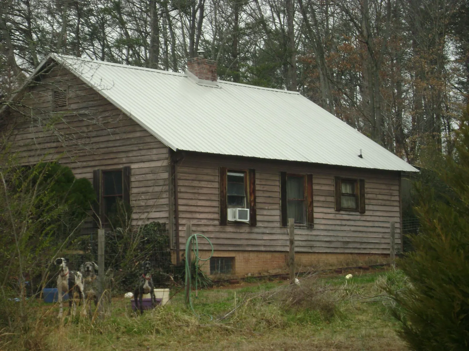 White metal roof on an old wood sided farmhouse, from a Asphalt Shingle Roof Repair job in Locust Grove